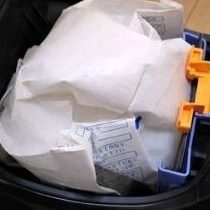 掃除機に紙パックをセットしている様子（各社共通タイプ）